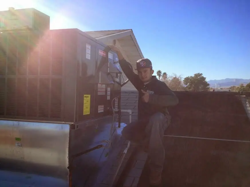 HVAC technician performing AC Tune-Up on a rooftop unit in Bonner Springs